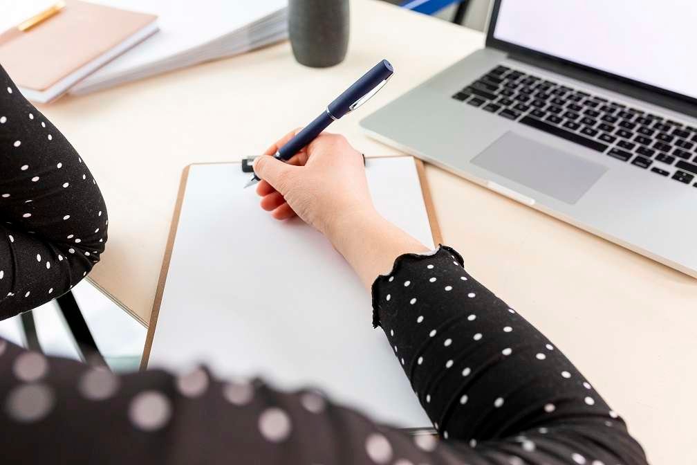 high angle business woman taking notes clipboard